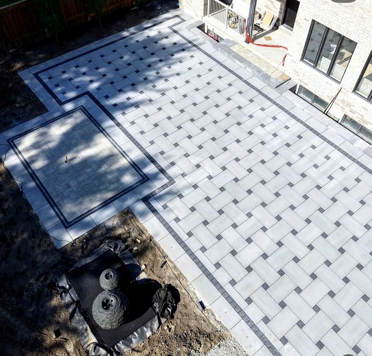 Drone view of finished backyard interlock patio, shaded pad and stone features — completed Pisces project in Toronto
