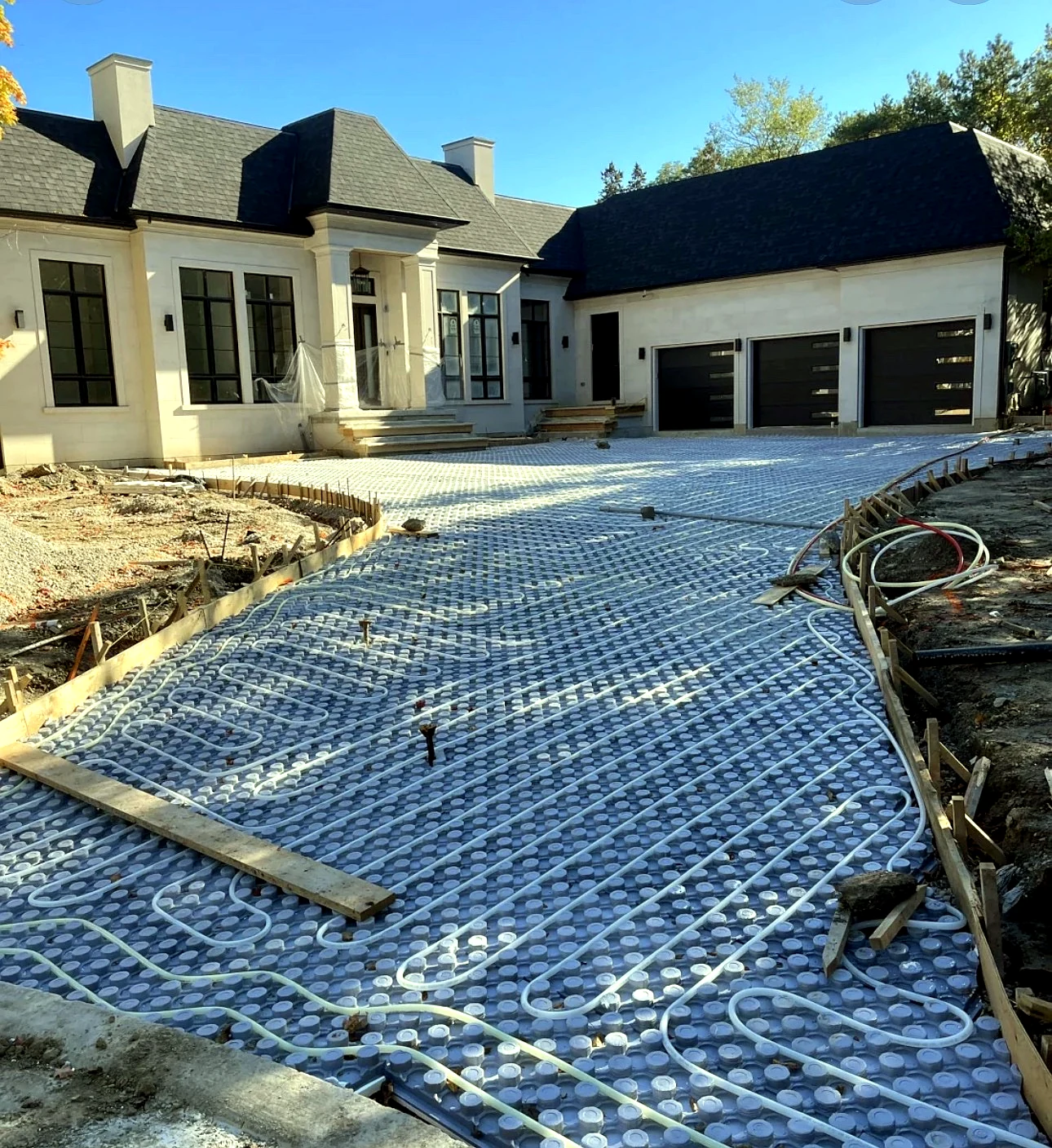 Real Pisces work — hydronic snow-melting heating loops laid wall-to-wall on a large driveway