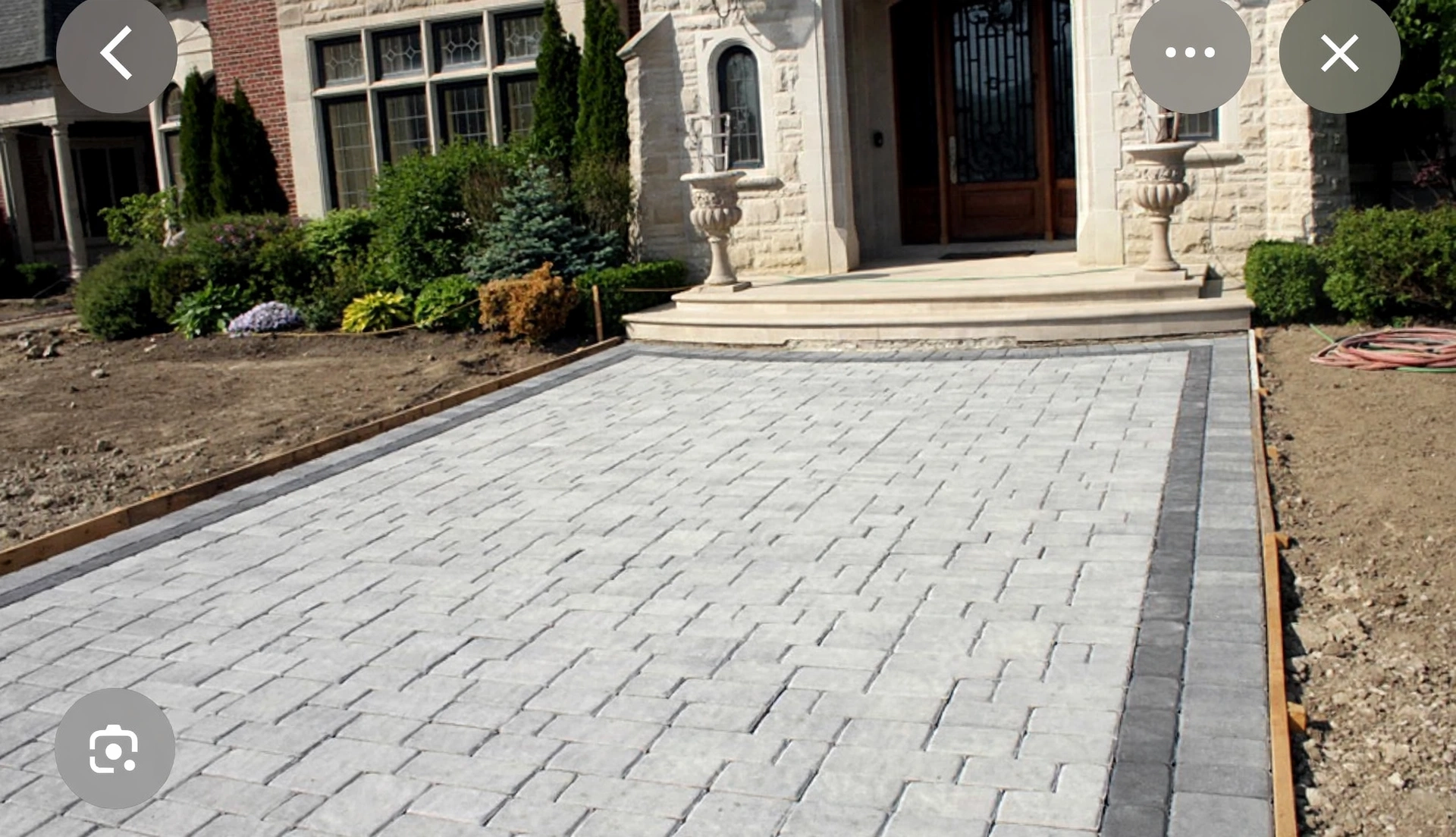 Design concept — finished front walkway visualization with light-grey interlock pavers and charcoal border accents