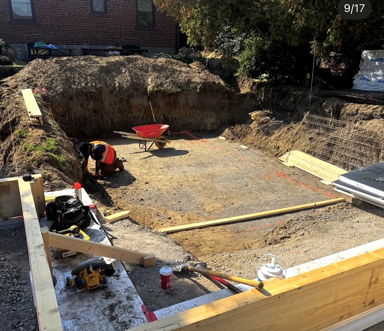 Real Pisces jobsite: crew member doing layout work in the excavated foundation pit